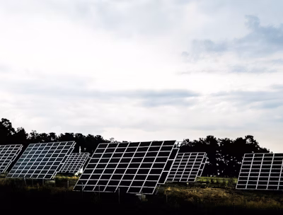 silhouette photography of assorted solar panel behind trees